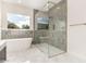 Bathroom featuring soaking tub and glass enclosed shower with grey tiled accent wall at 1645 E Minton St, Mesa, AZ 85203