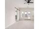 Spacious bedroom with cozy carpet, patio access, and a modern sliding barn door leading to ensuite bathroom at 1645 E Minton St, Mesa, AZ 85203