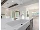 Close up of sink and quartz countertop in kitchen with gas range, wood beams, and a tiled fireplace at 1645 E Minton St, Mesa, AZ 85203