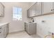Well-lit laundry room with gray cabinets and a sink at 1645 E Minton St, Mesa, AZ 85203