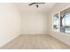 An empty room is shown with tile floors, white walls, base trim, and natural light from an outside window at 1645 E Minton St, Mesa, AZ 85203