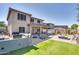 Spacious backyard featuring an outdoor kitchen, artificial turf, desert landscaping, and a covered patio at 16532 W Rowel Rd, Surprise, AZ 85387