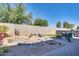 Backyard features an outdoor kitchen, a fire pit and seating area, and desert landscaping at 16532 W Rowel Rd, Surprise, AZ 85387