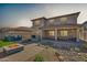 This backyard features a fire pit, outdoor kitchen, patio, and desert landscaping at 16532 W Rowel Rd, Surprise, AZ 85387