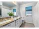 Bright bathroom with double sinks, granite countertop, and a framed mirror, offering a modern aesthetic at 16532 W Rowel Rd, Surprise, AZ 85387