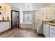 Elegant bathroom with tiled floor, a soaking tub with glass block surround, and granite countertops at 16532 W Rowel Rd, Surprise, AZ 85387