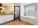 Large bathroom featuring a soaking tub, glass block accents, granite countertops, and a separate toilet room at 16532 W Rowel Rd, Surprise, AZ 85387