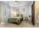 Cozy bedroom with wood-look floors, decorative artwork, and a barn door at 16532 W Rowel Rd, Surprise, AZ 85387