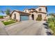 Stunning home exterior featuring a two-car garage, an arched entryway, and beautiful landscaping at 16532 W Rowel Rd, Surprise, AZ 85387