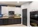 A kitchen featuring sleek black appliances, granite countertops, and stylish white and gray cabinetry at 16532 W Rowel Rd, Surprise, AZ 85387
