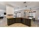 This kitchen area features an eat-in island, stainless steel appliances, and a view into a living space at 16532 W Rowel Rd, Surprise, AZ 85387