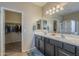 Bright bathroom featuring double sinks, ample counter space, and a walk-in closet at 16830 W Magnolia St, Goodyear, AZ 85338