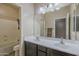 Bright bathroom featuring double sinks, ample counter space, and vanity lighting at 16830 W Magnolia St, Goodyear, AZ 85338