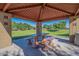 Shaded picnic area in the community with a table and benches overlooking a spacious grassy park at 16830 W Magnolia St, Goodyear, AZ 85338