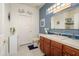 Bathroom with blue accent wall, wood cabinets and tile countertop, and decorative mirror at 19140 N Tamarisk Flower Way, Surprise, AZ 85387