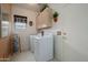 Convenient laundry room with a full size washer and dryer and built in upper storage cabinets at 19140 N Tamarisk Flower Way, Surprise, AZ 85387