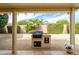 Covered patio with built-in grill and lush landscaping offering an outdoor entertaining space at 19140 N Tamarisk Flower Way, Surprise, AZ 85387