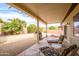 Inviting covered patio with lounge chairs, built-in grill, and landscaped backyard with desert plants at 19140 N Tamarisk Flower Way, Surprise, AZ 85387
