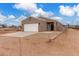 Inviting home exterior featuring a spacious driveway, stylish stone accents, and desert landscape at 21816 W Taft Ave, Wittmann, AZ 85361