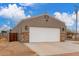 Inviting home exterior featuring a spacious driveway, stylish stone accents, and desert landscape at 21816 W Taft Ave, Wittmann, AZ 85361