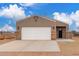 Inviting home exterior featuring a spacious driveway, stylish stone accents, and desert landscape at 21816 W Taft Ave, Wittmann, AZ 85361