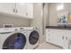 Practical laundry room with new washer and dryer, storage cabinets, and countertop at 21816 W Taft Ave, Wittmann, AZ 85361