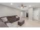 Bright living room features neutral walls, tile flooring, a ceiling fan, and a comfortable sectional at 21816 W Taft Ave, Wittmann, AZ 85361