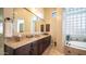 Beautiful bathroom with granite countertops, dark wood cabinets, and a relaxing tub at 2224 N 83Rd Cir, Mesa, AZ 85207