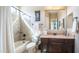 Well-lit bathroom featuring a tub-shower, single sink vanity, and decorative mirror at 2224 N 83Rd Cir, Mesa, AZ 85207