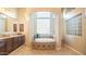 Serene primary bathroom with a soaking tub, dark wood cabinets and granite countertop vanity offering a spa-like retreat at 2224 N 83Rd Cir, Mesa, AZ 85207