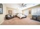 Spacious bedroom featuring a ceiling fan, plantation shutters and sitting area at 2224 N 83Rd Cir, Mesa, AZ 85207