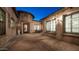 Exterior view of a private patio featuring brick pavers, stone accents, and an outdoor dining area with ample natural light at 2224 N 83Rd Cir, Mesa, AZ 85207