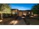 Inviting front entryway with stone facade, brick pathway, and decorative gate, illuminated by charming outdoor lighting at 2224 N 83Rd Cir, Mesa, AZ 85207