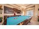 Well-lit game room featuring a pool table, custom built-in cabinets, and a decorative chandelier at 2224 N 83Rd Cir, Mesa, AZ 85207