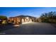 View of the home's exterior highlighting a spacious driveway and garage with stone accents and attractive landscaping at 2224 N 83Rd Cir, Mesa, AZ 85207