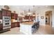 A spacious kitchen featuring dark wood cabinetry, granite countertops, a large island, and stainless steel appliances at 2224 N 83Rd Cir, Mesa, AZ 85207