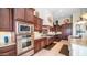Gourmet kitchen with dark wood cabinets, stainless steel appliances, and subway tile backsplash at 2224 N 83Rd Cir, Mesa, AZ 85207
