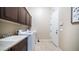 Laundry room with sink, cabinets and tiled floor at 2224 N 83Rd Cir, Mesa, AZ 85207