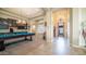 Open-concept living space featuring a pool table, built-in bar area, and elegant chandelier lighting at 2224 N 83Rd Cir, Mesa, AZ 85207