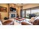 Inviting living room featuring a stone fireplace, comfortable leather seating, and seamless indoor-outdoor flow at 2224 N 83Rd Cir, Mesa, AZ 85207