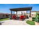 Outdoor kitchen and dining area with built-in grill, comfortable seating, and a pergola for shade at 2224 N 83Rd Cir, Mesa, AZ 85207