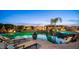 Backyard pool and spa with a well-lit landscape and comfortable lounge chairs at 2224 N 83Rd Cir, Mesa, AZ 85207