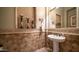 Stylish powder room with decorative tile, pedestal sink, and elegant accents, perfect for guests at 2224 N 83Rd Cir, Mesa, AZ 85207