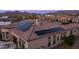 Aerial view of a home with solar panels, barrel tile roof, and mountain views at 2224 N 83Rd Cir, Mesa, AZ 85207