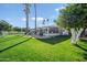 Large grassy backyard with tall palm trees, trees with white trunks, and screened in patio at 2251 N 32Nd St # 10, Mesa, AZ 85213