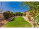 Expansive backyard with a neatly manicured lawn, mature landscaping and a charming stone-lined garden at 2263 E Jade Ct, Chandler, AZ 85286
