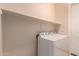 A laundry room with white washer and dryer, shelf above the units and a white door at 2263 E Jade Ct, Chandler, AZ 85286