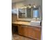 Bathroom featuring wood cabinets, framed mirror and vessel sink at 24638 N 65Th Ave, Glendale, AZ 85310