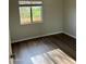 Bright bedroom features hardwood floors and a window with a view of trees and foliage at 24638 N 65Th Ave, Glendale, AZ 85310