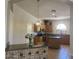 Open concept kitchen with granite countertops, wooden cabinets, and tile flooring at 24638 N 65Th Ave, Glendale, AZ 85310